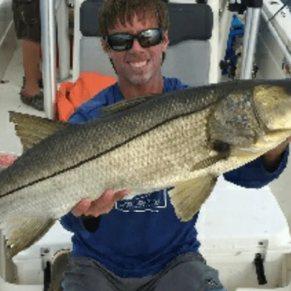 Captain Ryan Taylor holding a fish on the water